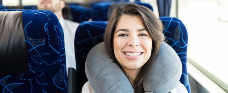 a woman on a charter bus with a neck pillow