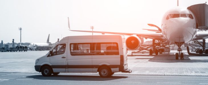 A shuttle bus rental parked outside of an airplane